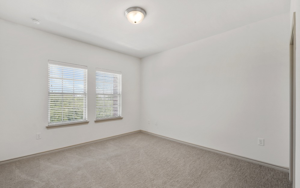 carpeted bedroom with windows