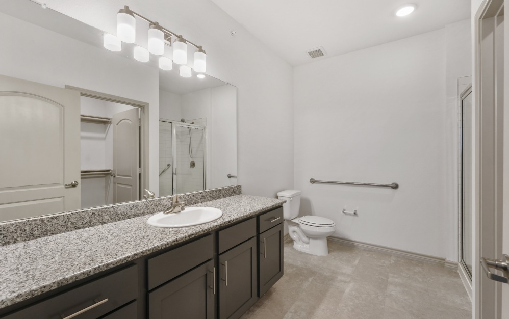 Spacious bathroom with lighting and toilet